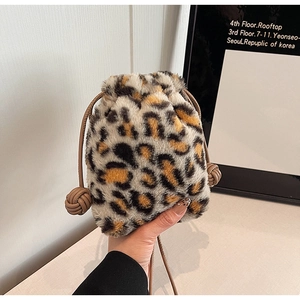 Detailed view of leopard print plush bucket bag featuring drawstring and knot details