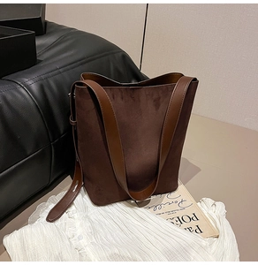 Detailed view of dark brown suede bucket bag with smooth leather strap for autumn
