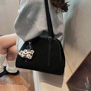 Détail du sac à épaule en similicuir noir avec bretelles et charm à motif léopard