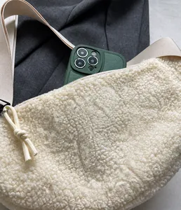 Detail der cremeweißen Teddy-Umhängetasche mit Reißverschluss und Web-Schultergurt