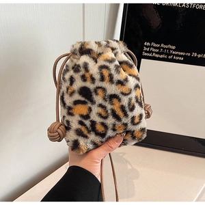Detail of leopard print plush bucket bag with drawstring and woven leather charms