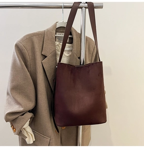 Detail of minimalist dark brown suede tote bag featuring a spacious trapezoid design