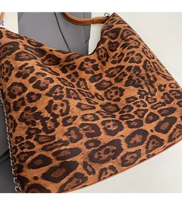 Detailed view of leopard print tote bag featuring plush fabric and leather straps