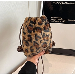 Detail of plush leopard print bucket bag with brown leather drawstring closure