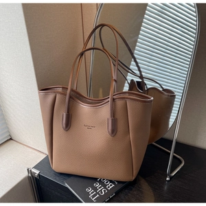 Detail of a brown lychee pattern leather tote bag with fashion trend text engraving