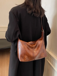 Grand sac cabas vintage en simili cuir marron brillant porté de dos pour un style élégant