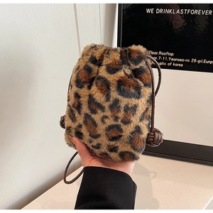Detail of leopard print plush bucket bag featuring soft faux fur and woven drawstring strap