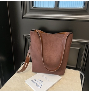Detailed view of caramel suede tote bag texture and seamless leather shoulder strap stitching