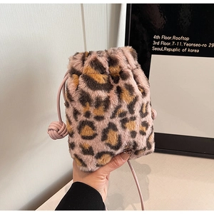 Detail of leopard print faux fur bucket bag with pink leather drawstring and strap