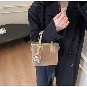 Sac seau en daim marron avec garniture en cuir vert et breloque monstre en peluche