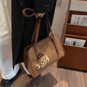 Détail du sac cabas en daim marron avec pompon léopard et bandoulière en cuir