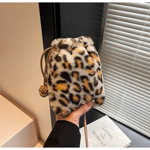 Detail of leopard print faux fur bucket bag featuring a brown leather drawstring closure