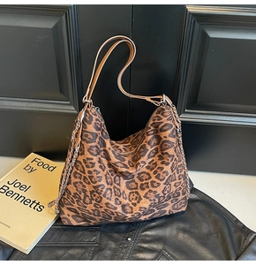 Macro shot of large leopard print hobo bag with brown leather strap and silver chain details