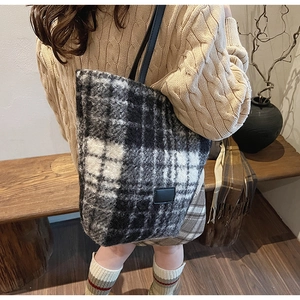 Dettaglio della borsa tote a quadri bianchi e neri con texture soffice e spalline sottili