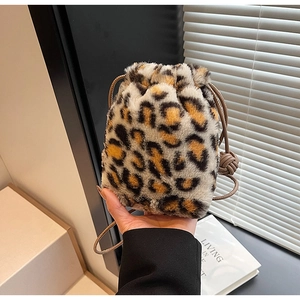 Detail of leopard print faux fur bucket bag showing soft plush texture and drawstring close