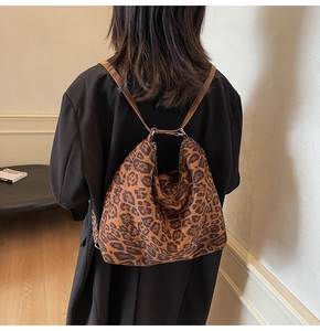 Detailed back view of a large leopard print tote bag worn by a model in casual setting
