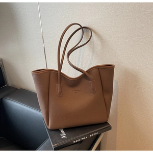 Detail of dark brown tote bag in pebbled texture with Fashion trend Souke logo print