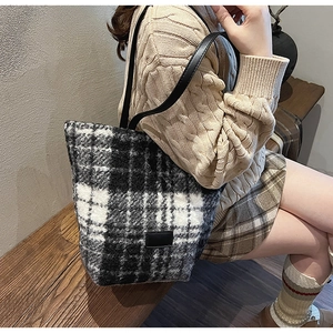 Dettaglio della borsa tote in tweed a quadretti bianchi e neri con tracolla in pelle
