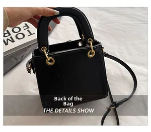 Detailed back view of a black pleated leather handbag with gold eyelets and round handle