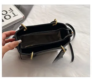 Detail showing the internal compartments and lining of the black leather handbag