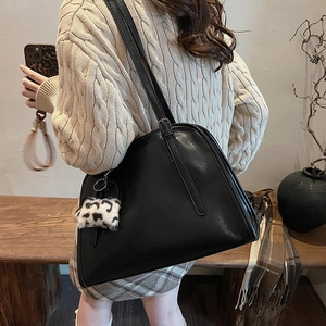 Vue détaillée du cabas en cuir noir avec breloque léopard porté par un mannequin