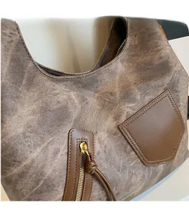 Detail shot of distressed brown fabric and metal zipper on a retro crossbody bag