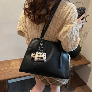 Détail du sac cabas en similicuir noir avec un charmant pendentif de chien en peluche