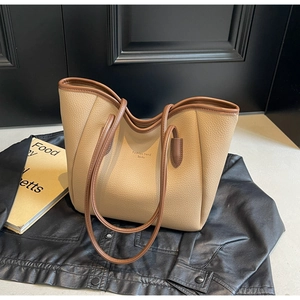 Detail of beige lychee grain leather tote bag with brown edges and Fashion Trend text