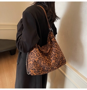 Detail of leopard print tote bag with brown leather and silver chain strap