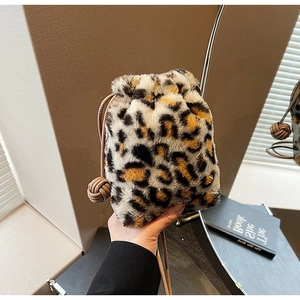 Detail of leopard print plush bucket bag featuring drawstring closure and thin leather strap
