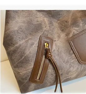 Close-up of vintage brown tote bag with premium leather texture and smooth metal zipper