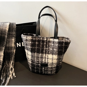 Dettaglio della trama in tweed bianco e nero su un'elegante borsa tote invernale