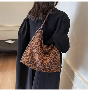 Detailed view of the leopard print tote bag with brown strap and silver chain accent