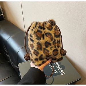 Detail of leopard print plush bucket bag featuring brown leather drawstring closure