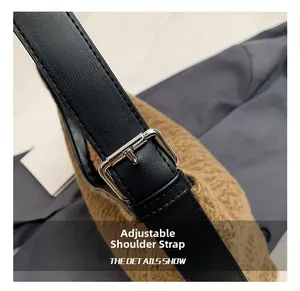 Detail of adjustable black leather strap with silver buckle on brown fuzzy shoulder bag