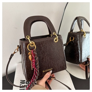 Detailed macro shot of dark brown glossy leather handbag with a reflective mirror effect