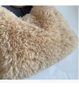 Close-up of the beige sherpa fleece fabric texture and durable handle on a tote bag
