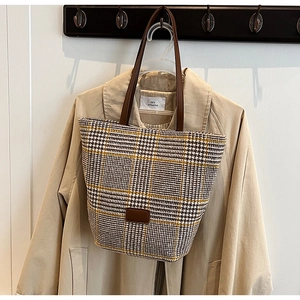 Dettaglio borsa shopper scozzese retrò con manici in pelle marrone e toppa decorativa