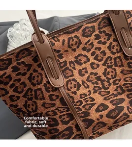 Gros plan du sac cabas léopard montrant la texture douce du daim et les détails en cuir