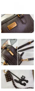 Macro detail of dark brown leather texture and premium metal hardware on Boston bag