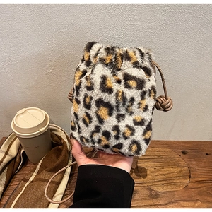 Detail of plush leopard print bucket bag with faux fur texture and drawstring closure