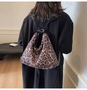 Detail of leopard print tote bag with metallic chain and black strap on winter coat