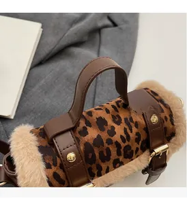 Détail d'un sac à main léopard en fausse fourrure avec anse cuir et boucle dorée