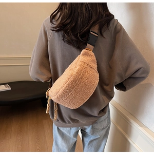 Close-up of camel fleece crossbody bag texture with adjustable strap and buckle