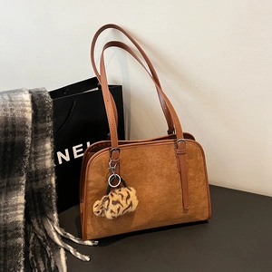 Détail du sac à bandoulière en daim caramel avec breloque léopard et boucle métallique
