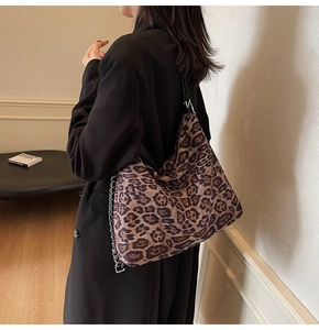 Close-up of leopard print hobo bag with wide strap and silver metal chain detail