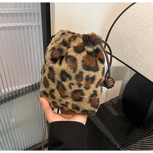 Detailed close-up of leopard print plush bucket bag with soft faux fur and brown drawstring