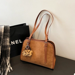 Détail du sac cabas en daim caramel avec pompon léopard et accessoires d'automne