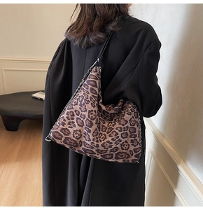 Detail of large leopard print tote bag with silver chain and black shoulder strap
