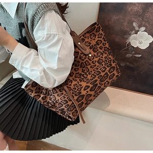 Detailed view of leopard print tote bag featuring brown leather straps and metal rivets